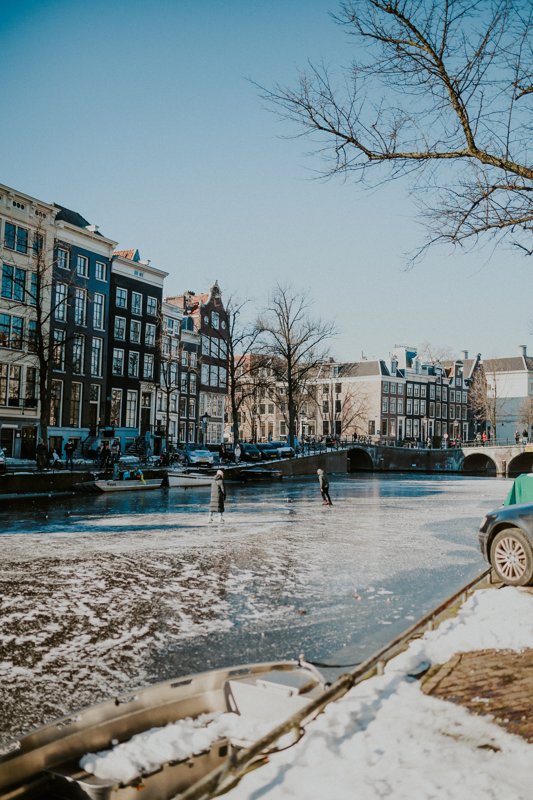 Frozen canals in Amsterdam, people skating