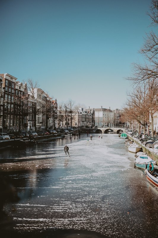Frozen canals in Amsterdam, people skating